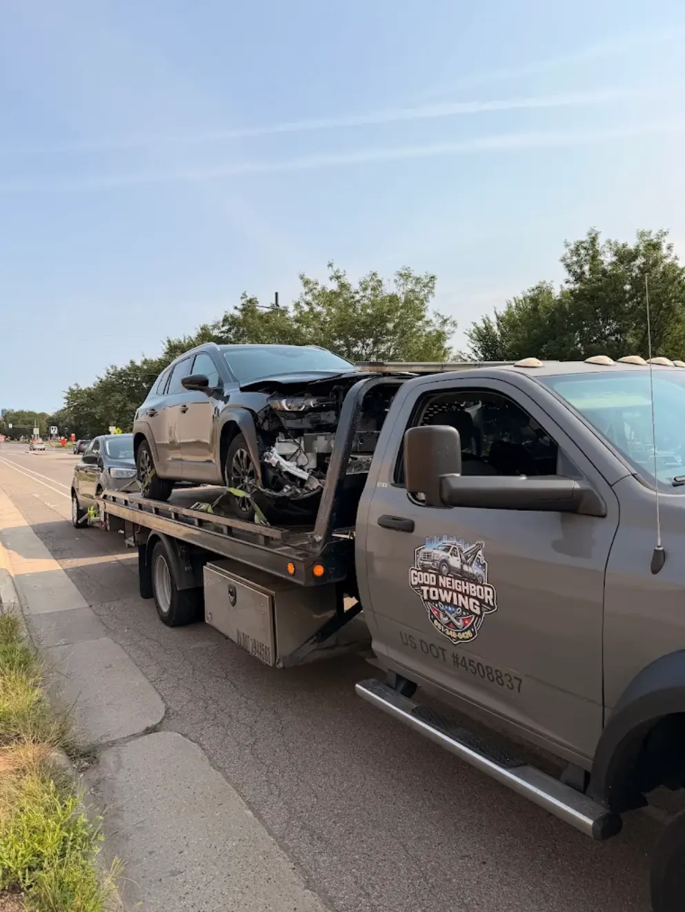 Damaged vehicle secured on the Good Neighbor Towing flatbed after a Twin Cities emergency tow