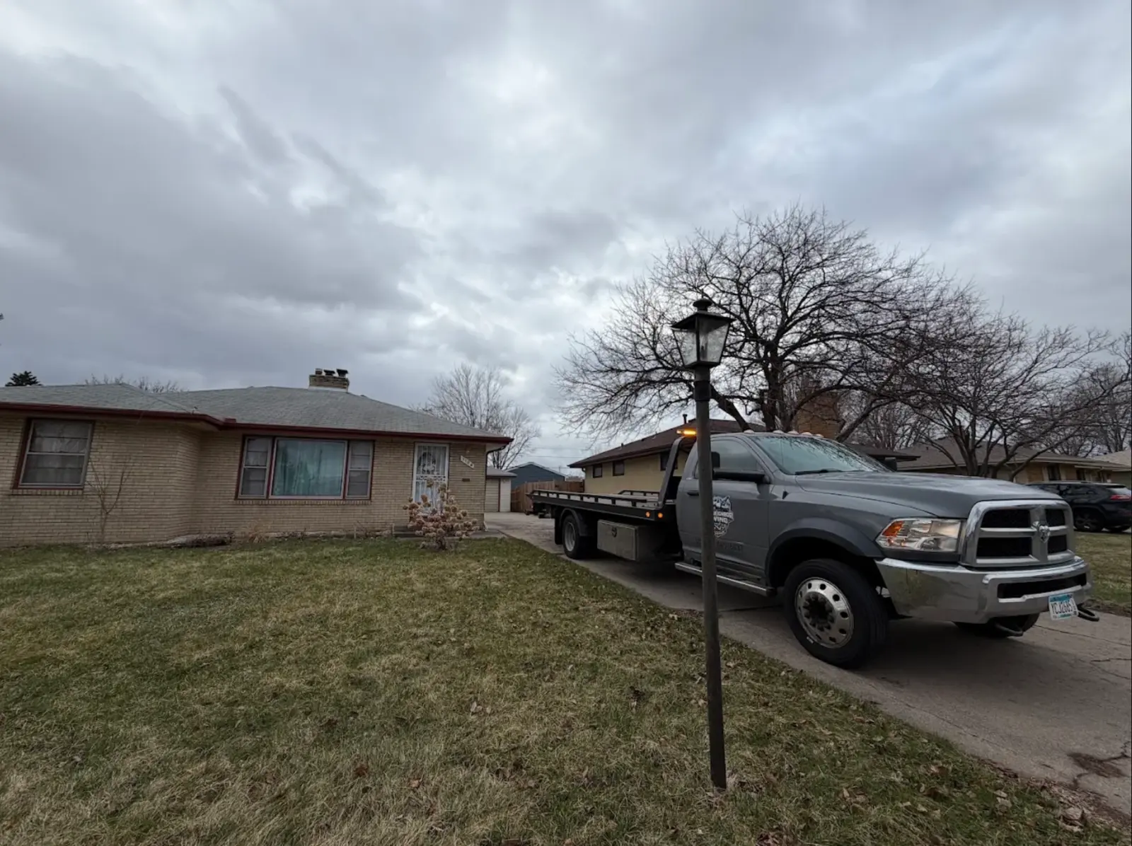 Flatbed tow truck serving a residential street in the Twin Cities